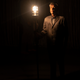 David Byrne stands next to a lamp in a scene from American Utopia